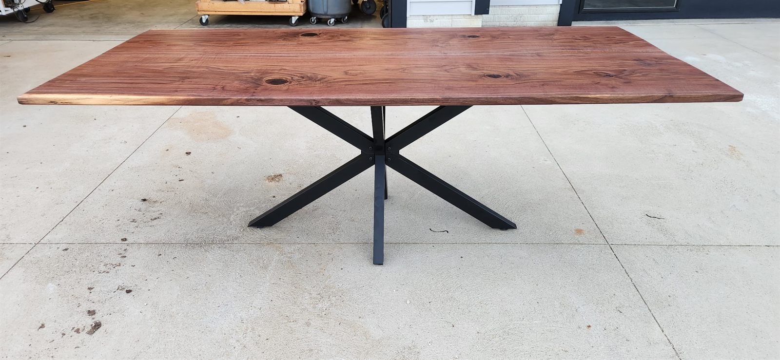 Live edge black walnut table on a black steel spider base
